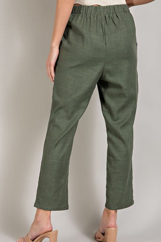 Green pants worn by a person on a plain background