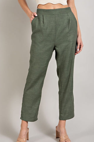 Green pants worn by a person on a plain background