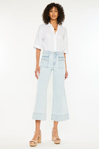 Lady standing wearing crop length, pinstripe jeans. 