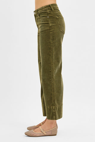 Green pants worn by a person on a white background