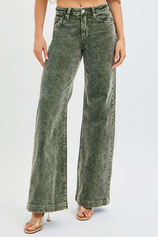 Person wearing acid-wash green jeans on a white background