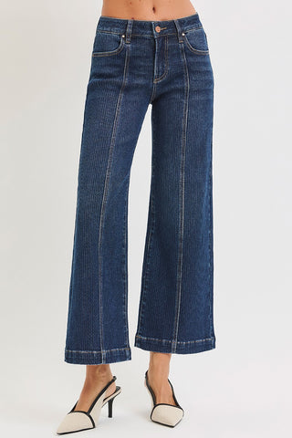 Blue jeans worn by a person on a white background