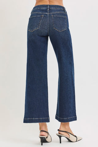 Blue jeans worn by a person on a white background