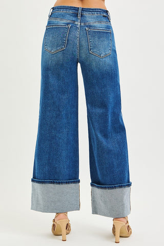 Blue wide-leg jeans with cuffed hems on a white background