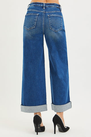 Blue wide-leg jeans worn by a person on a white background