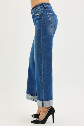 Blue jeans with rolled-up cuffs on a white background