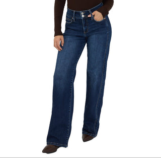 Woman wearing a brown long-sleeve top and blue jeans on a white background