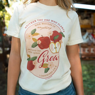 Person wearing a white t-shirt with a graphic design and text outdoors