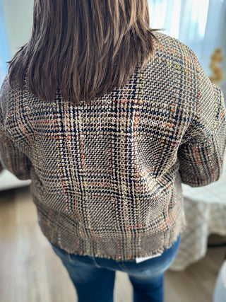 Person wearing a patterned sweater with a blurred background