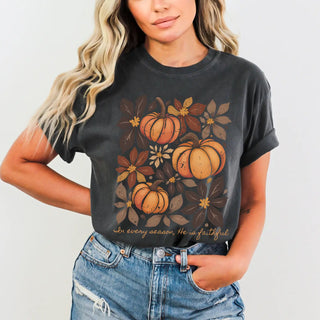 Person wearing a black t-shirt with pumpkin design and text on a plain background