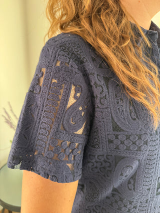 A navy blue button down dress with patch lace details and a collar, made of 100% cotton.