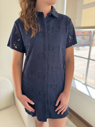 A navy blue button down dress with patch lace details and a collar, made of 100% cotton.