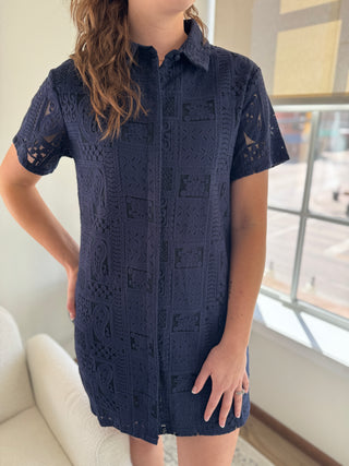 A navy blue button down dress with patch lace details and a collar, made of 100% cotton.