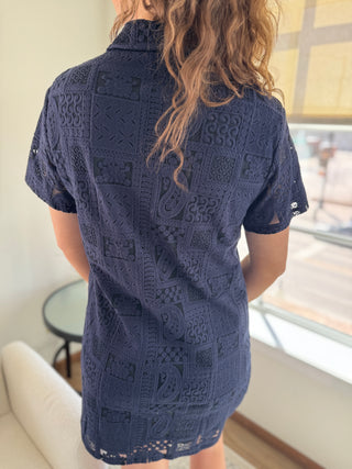 A navy blue button down dress with patch lace details and a collar, made of 100% cotton.
