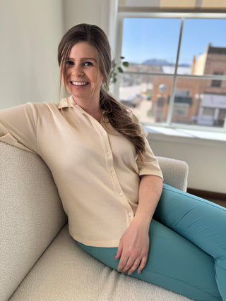 Gal sitting on couch wearing ivory waffle knit button up top.