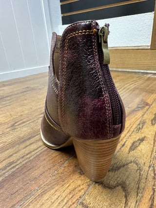 Brown leather ankle boot on a wooden floor