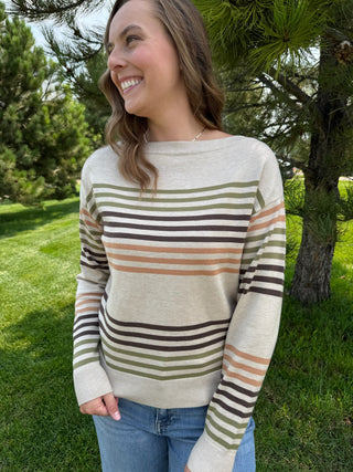 Gal standing outside wearing a taupe striped sweater