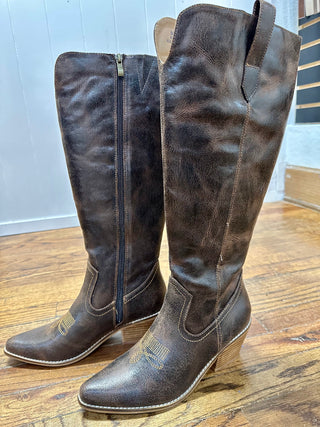 Pair of brown knee-high boots on a wooden floor.