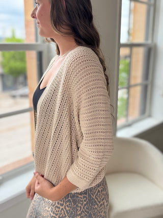 Woman wearing a tan knit cardigan