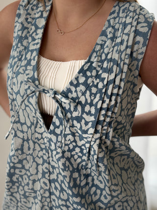Blue and beige patterned sleeveless top worn by a person.