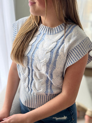Person wearing a patterned sweater with a blurred background