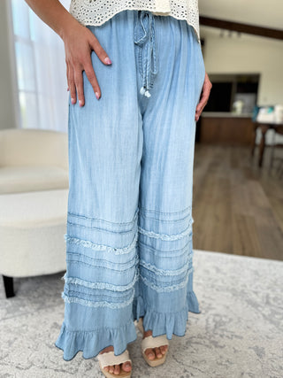 Light blue ruffled pants worn by a person in a home setting