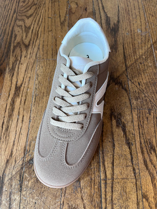 Beige sneaker on a wooden surface