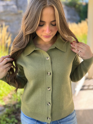 Model is wearing a green cardigan.
