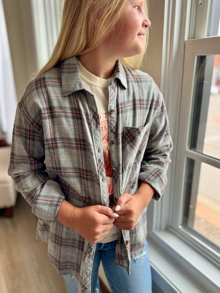 Person wearing a plaid shirt in a room with a window