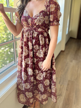Photo of a woman wearing a burgundy floral dress.