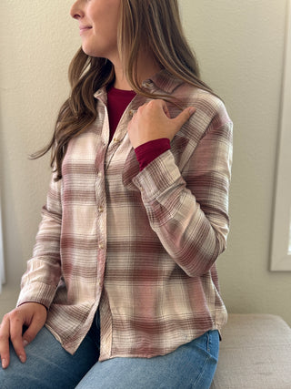 Woman wearing a plaid shirt with a neutral background