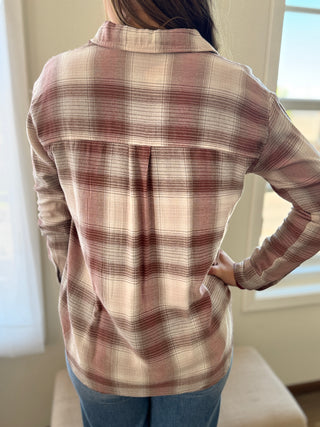 Person wearing a plaid shirt in a room with a window in the background
