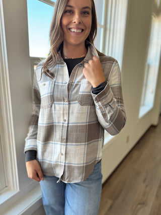 Woman wearing a plaid shirt and jeans indoors