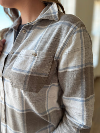 Close-up of a person wearing a plaid shirt with a pocket.