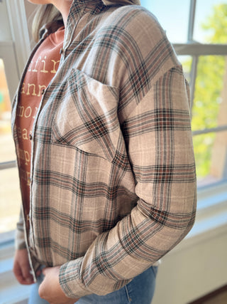 Person wearing a plaid shirt with a blurred background