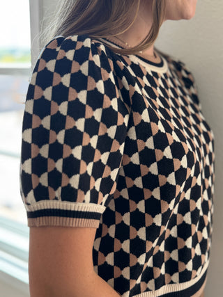 Person wearing a patterned shirt with geometric design