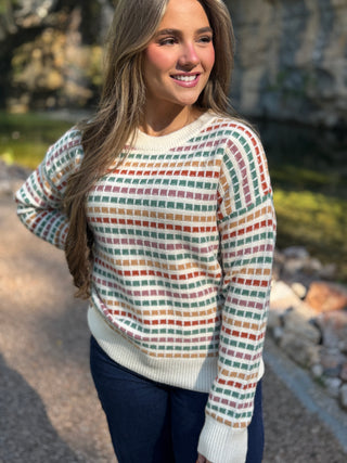 Woman in a cream grid knit sweater with colorful dash stripes | V-Rae's Boutique