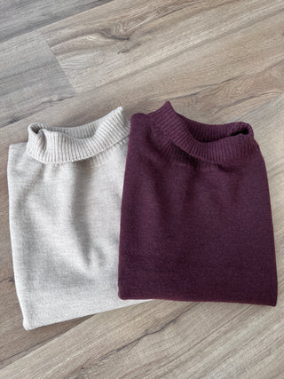 Folded purple and gray sweater on a wooden floor