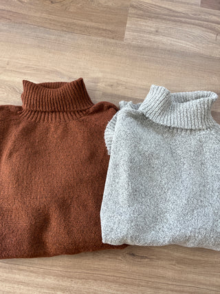 Gray and brown knitted sweaters on a wooden floor