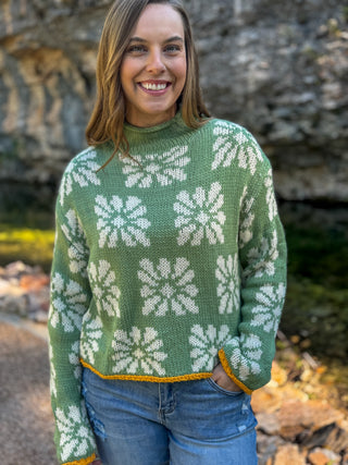 Woman in a sage green mock neck sweater with white daisy print | V-Rae's Boutique
