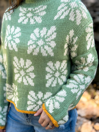 Close-up of the white daisy knit and mustard hem on a green sweater | V-Rae's Boutique