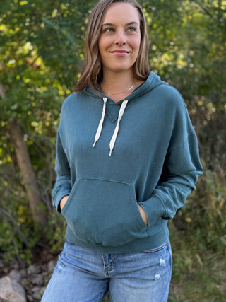 Woman in a teal vintage wash pullover hoodie with jeans | V-Rae's Boutique