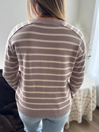 Person wearing a striped sweater with a neutral background