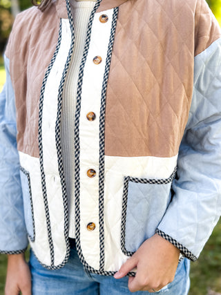 Close-up of gingham trim and tortoise buttons on a quilted jacket | V-Rae's Boutique