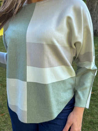 Close-up of the color-block knit and curved hem on a batwing sweater | V-Rae's Boutique