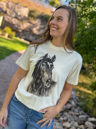 Woman in a cream graphic tee with a sketched black horse print | V-Rae's Boutique