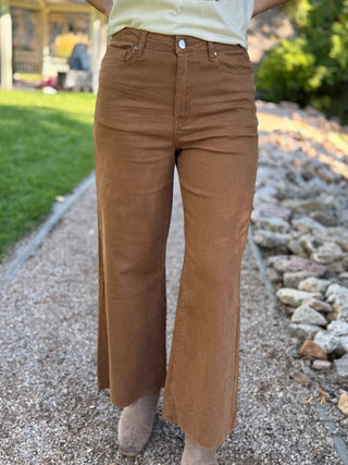 Front view of brown wide leg pants with a raw hem, worn with ankle boots | V-Rae's Boutique