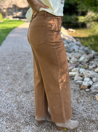 Side view of brown wide leg raw hem pants with a high waist | V-Rae's Boutique