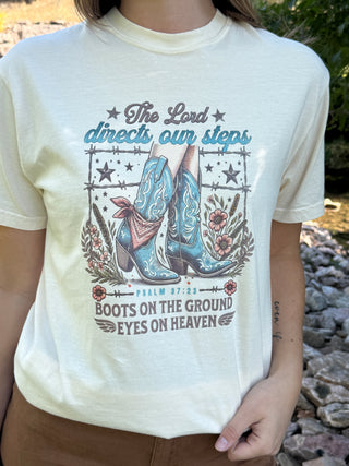Cream graphic tee with cowboy boots and 'The Lord Directs Our Steps' print | V-Rae's Boutique