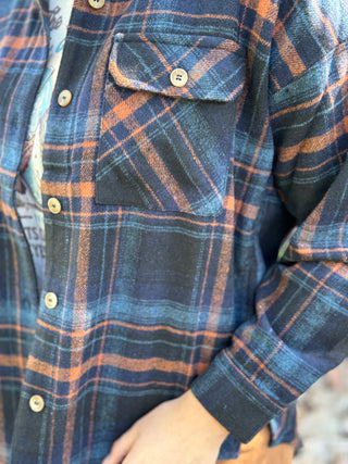 Close-up of the button flap pocket on a navy and orange plaid flannel shacket | V-Rae's Boutique